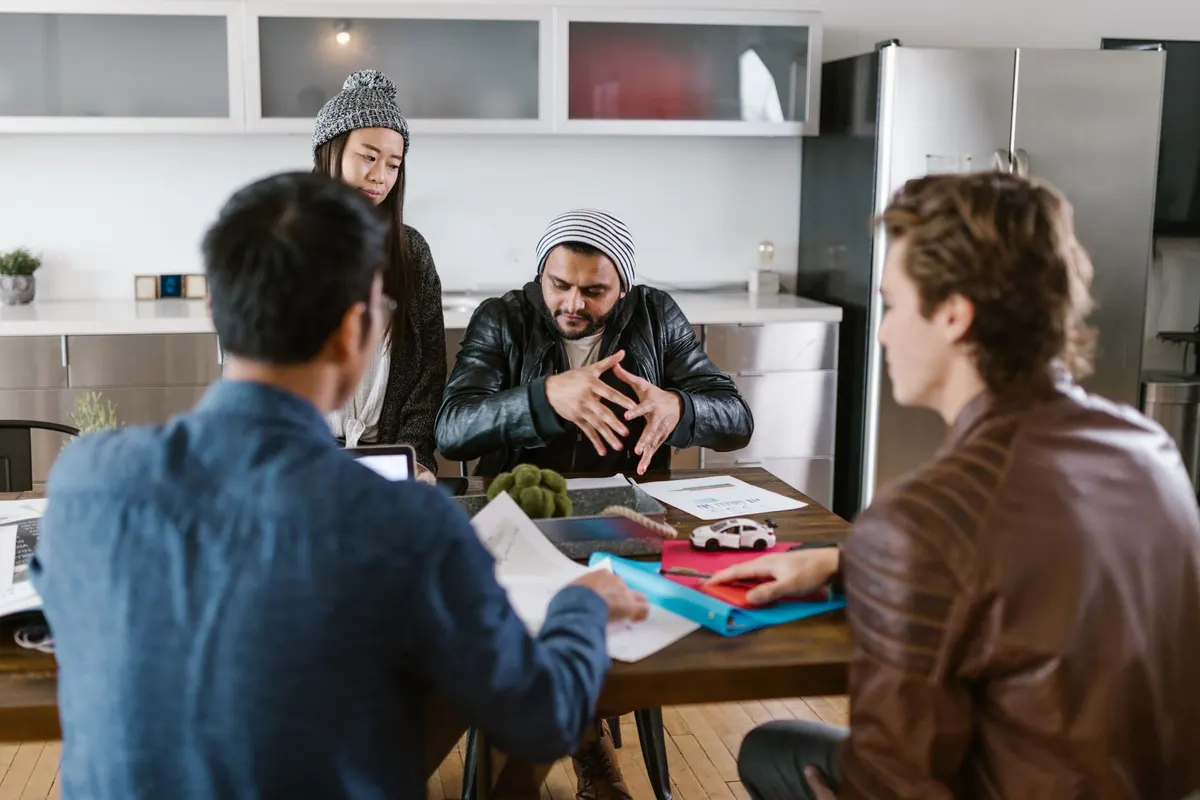 Colleagues sitting around a desk in an informal check-in conversation
